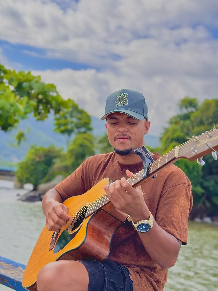 Músico com violão à beira do rio