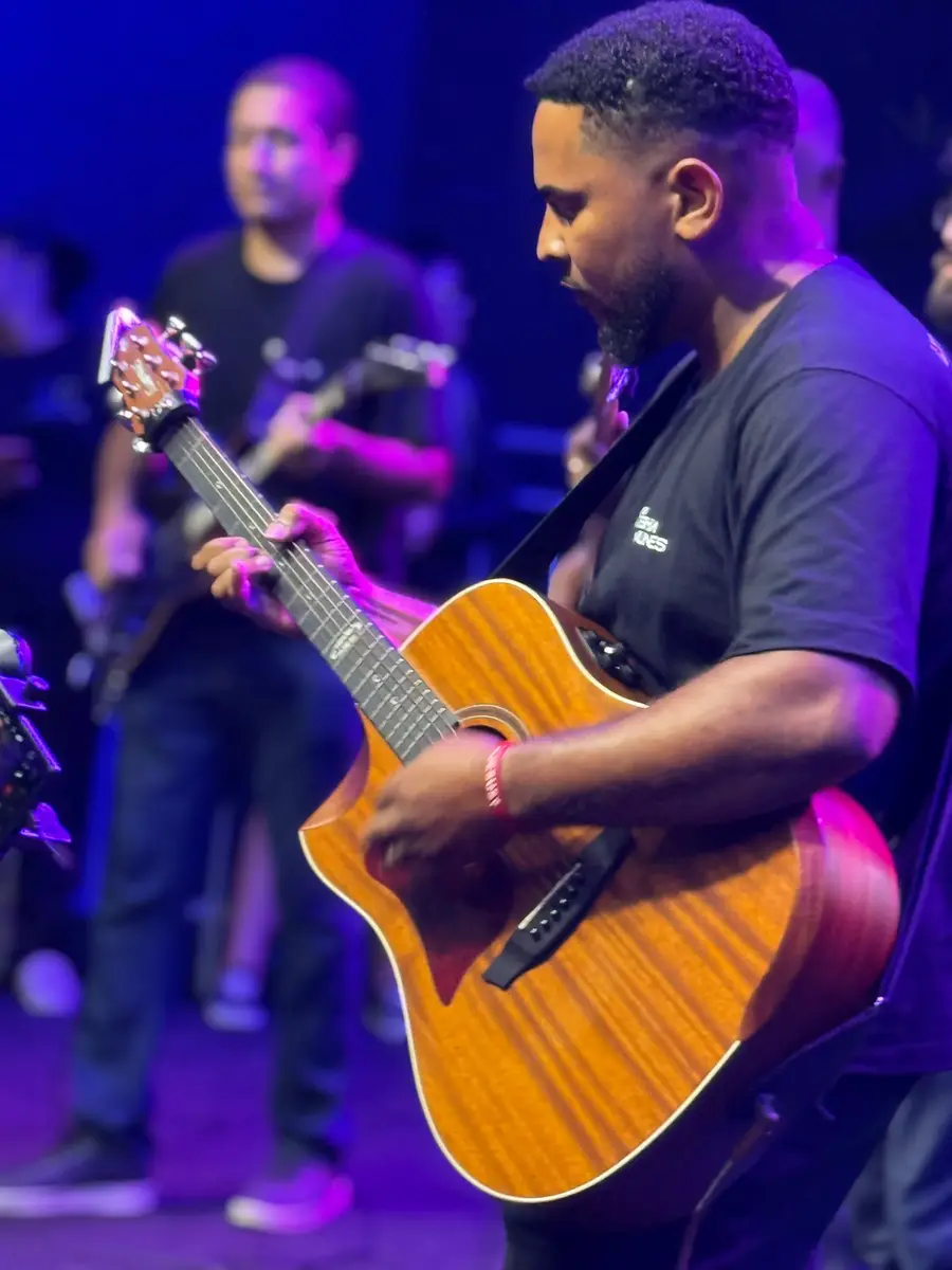 Guitarrista sob luz roxa no palco